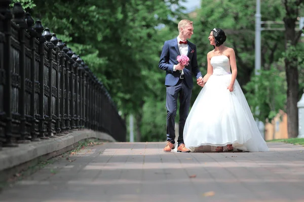 Mariée et marié promenade dans un parc de la ville — Photo