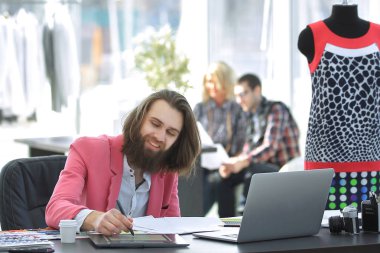 Moda Tasarımcısı modern bir stüdyoda masada.