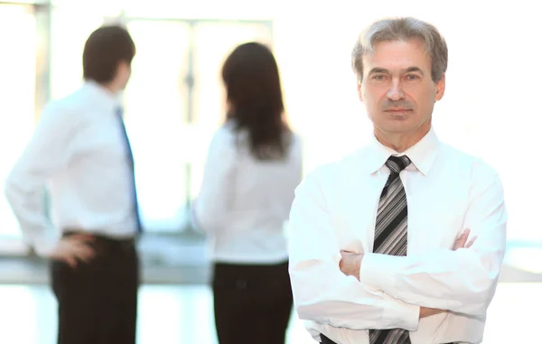 Portrait of a senior businessman on blurred background office — Stock Photo, Image
