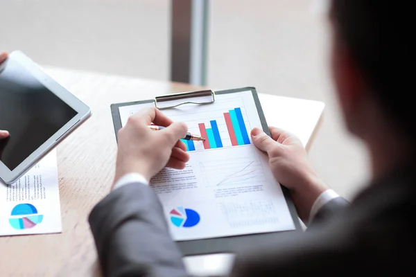 Nära up.businessman gör en ekonomisk rapport. bakifrån — Stockfoto