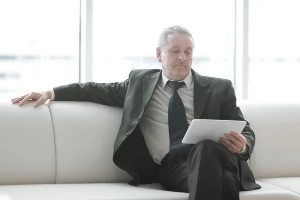 Hombre de negocios serio leyendo texto en una tableta digital — Foto de Stock