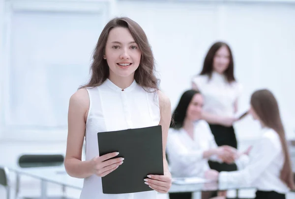 Självsäker ung affärskvinna med Urklipp på bakgrunden av business-team — Stockfoto