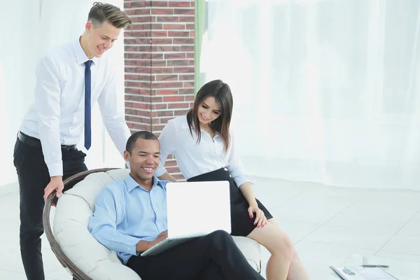 Exitoso empresario con sus asistentes en una discusión de la información de la computadora portátil. — Foto de Stock