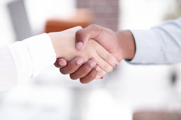 Closeup.greeting mulheres de negócios com um parceiro de negócios . — Fotografia de Stock