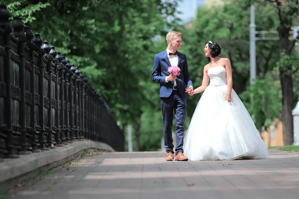 Bruden och brudgummen går tillsammans ner på gatan — Stockfoto