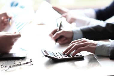 yakın çekim. iş takım bir hesap makinesi kullanarak hesaplamalar yapar