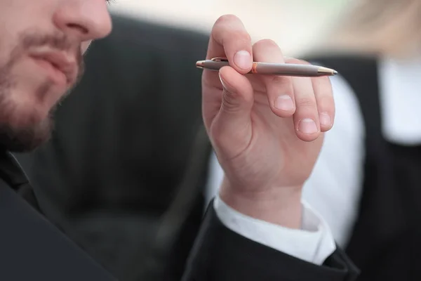 Nahaufnahme. Nachdenklicher Geschäftsmann mit Stift am Tisch — Stockfoto