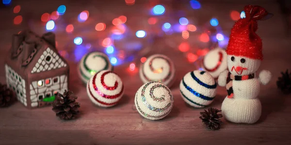 Kerstballen en een speelgoed sneeuwpop op kersttafel — Stockfoto