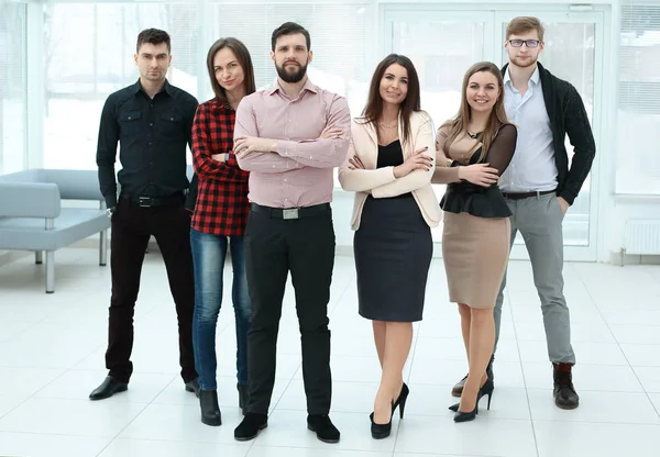 Em pleno crescimento.um grupo de empresários de pé em um escritório espaçoso — Fotografia de Stock