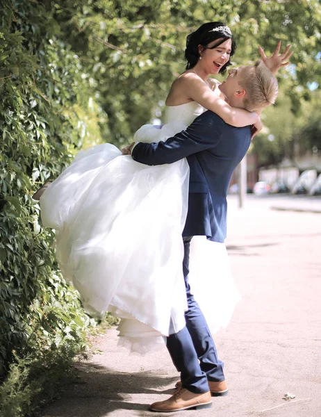 Šťastná nevěsta a ženich objímání na ulici — Stock fotografie