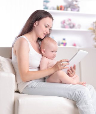 Anne ve bebek dijital tablet ekranına bakıyorlar.