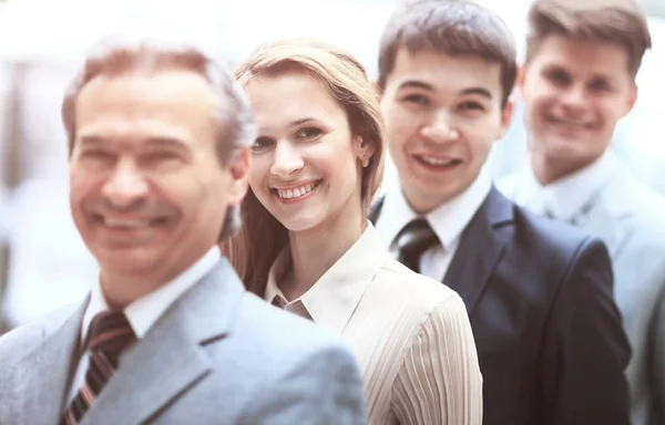 Счастливая улыбающаяся бизнес-команда, стоящая в ряд в офисе — стоковое фото
