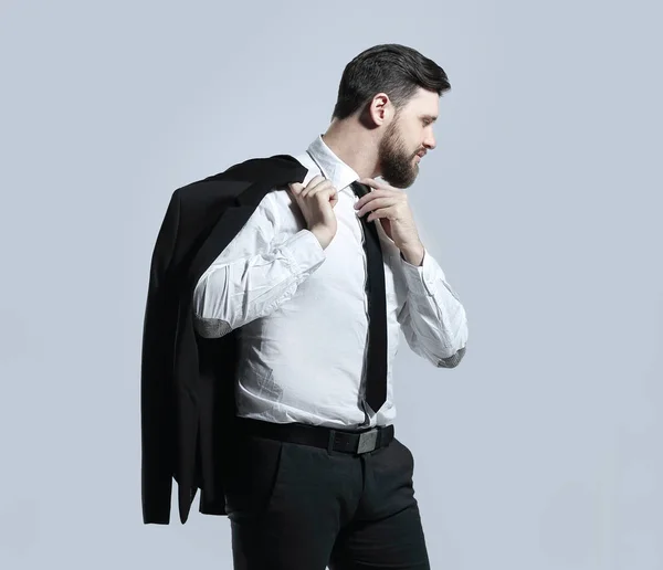 Businessman holding his jacket over his shoulder and straightens his tie — Stock Photo, Image