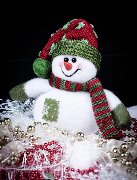 Juguete divertido muñeco de nieve y decoraciones de Navidad sobre un fondo negro — Foto de Stock