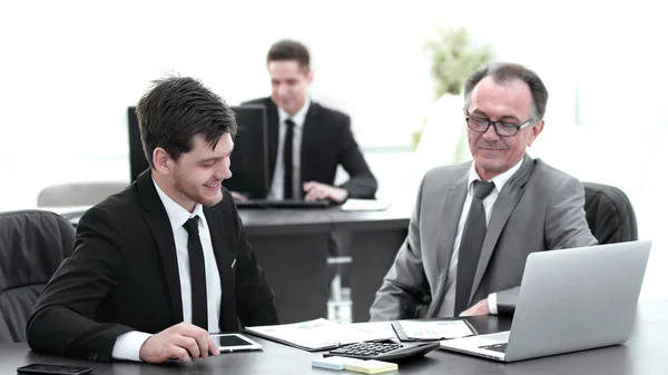 Jefe y empleado discutiendo el documento sentado en el escritorio en la oficina . — Foto de Stock