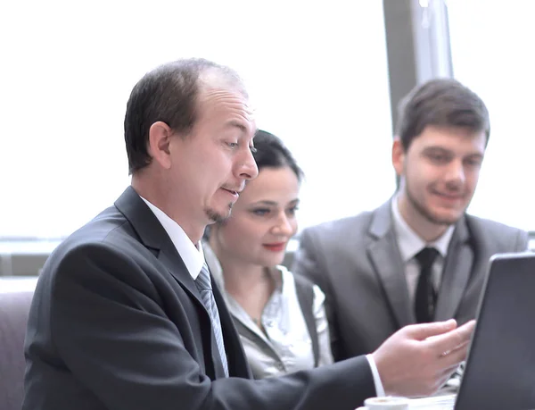 Equipo de empleados analiza los datos utilizando una computadora portátil — Foto de Stock