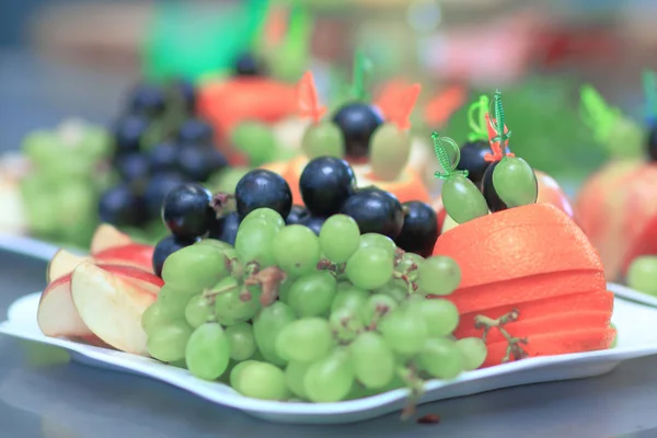 Close up.plate with grapes and oranges on blurred background — Stock Photo, Image