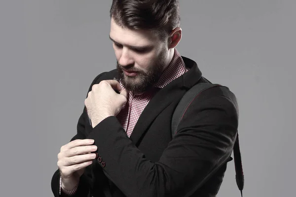 Professional photographer with camera, adjusting a cufflink.isolated on grey background — Stock Photo, Image