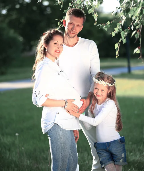 Felice padre e bambina abbracciare la madre incinta su un wa — Foto Stock