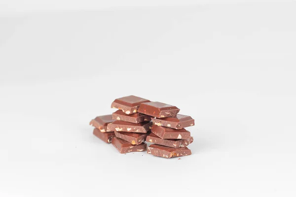 Kawałki gorzkiej czekolady z orzechami na białym tle na white.photo z — Zdjęcie stockowe