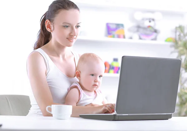 Junge Mutter nutzt Laptop für freiberufliche Arbeit zu Hause — Stockfoto