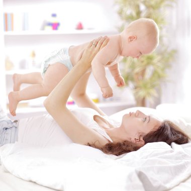 Genç Anne yatakta yatarken bebek çalış