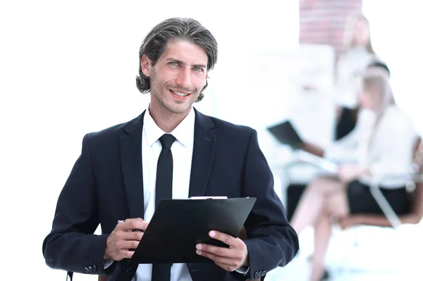 Красивый бизнесмен подписывает рабочую бумагу, сидя в офисе . — стоковое фото