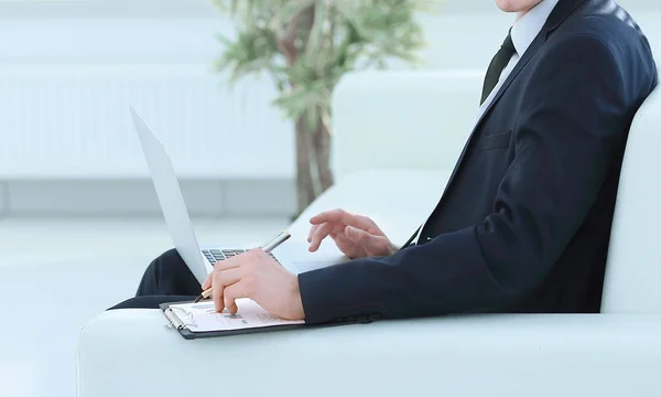 Selbstbewusster Geschäftsmann am Laptop sitzend in der geräumigen — Stockfoto