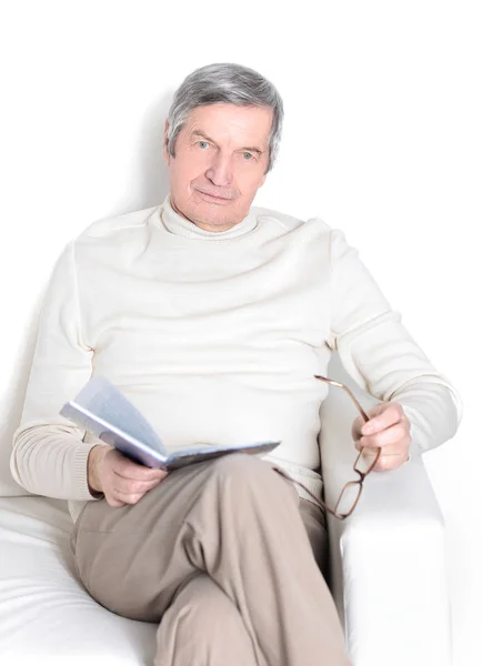 Elderly man with digital tablet sitting in a chair. — Stock Photo, Image