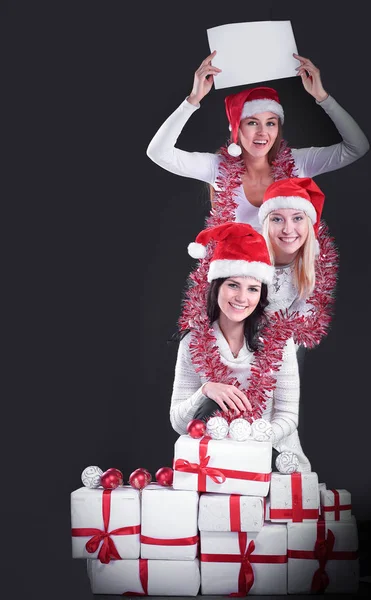 Tres chicas jóvenes en traje de Santa Claus mostrando hojas en blanco — Foto de Stock