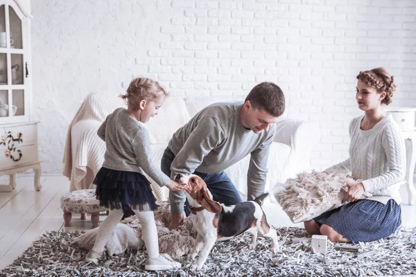 Szczęśliwa rodzina gry z pies w przestronny salon — Zdjęcie stockowe