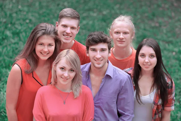 Retrato de um grupo de jovens bem sucedidos em um gramado verde — Fotografia de Stock