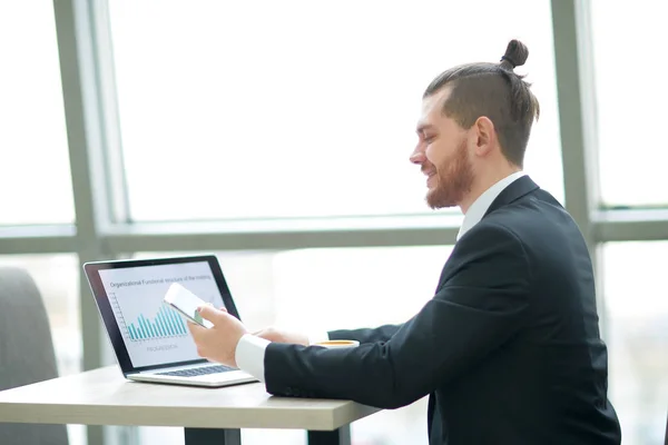 Homme d'affaires occasionnel travaillant avec mobile et ordinateur portable dans un bureau moderne — Photo