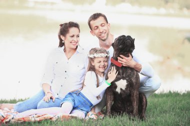 Güneşli bir yaz gününde piknikte köpekli mutlu bir aile. pregn