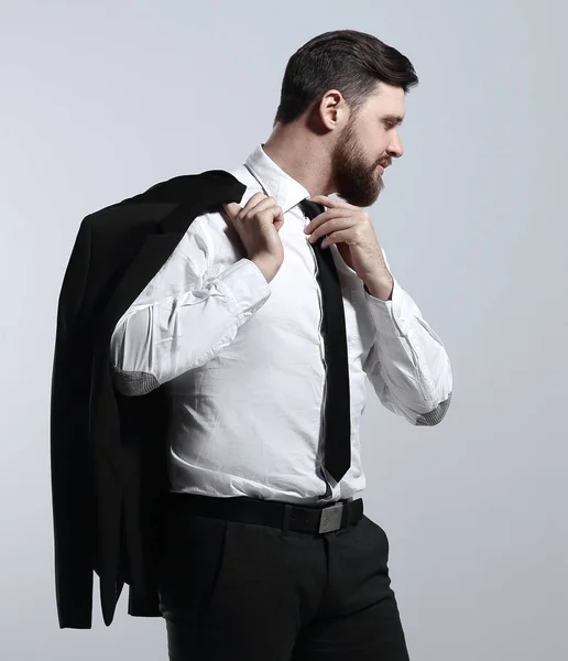 Επιχειρηματίας κρατώντας το σακάκι του πάνω από τον ώμο και ισιώνει τη γραβάτα του — Φωτογραφία Αρχείου