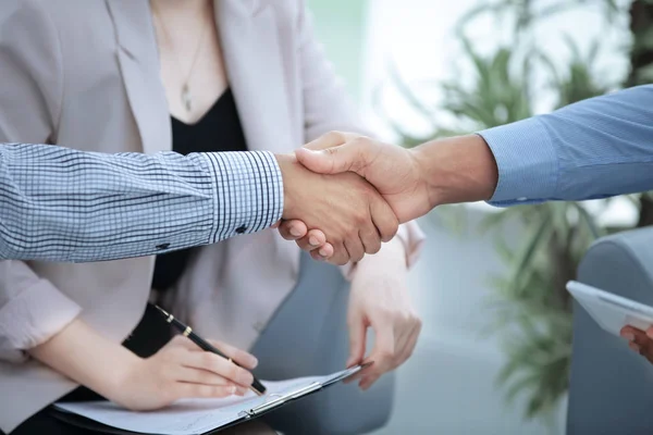 Closeup.handshake los socios financieros en el fondo de la oficina — Foto de Stock