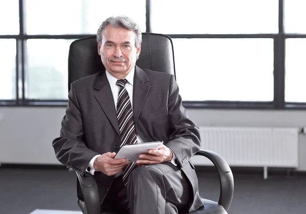 Уверенный бизнесмен с кожаной папкой, сидящий в офисе — стоковое фото