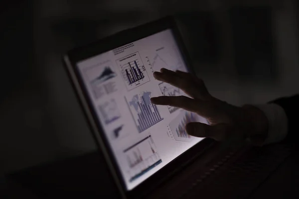Close up.Businessman pointing finger at laptop screen with financial chart — Stock Photo, Image
