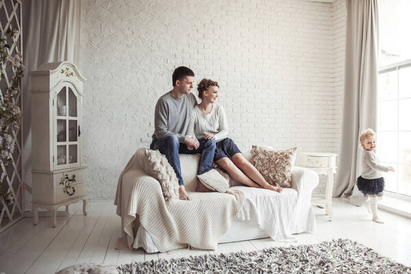 happy young family resting in living room on Sunday