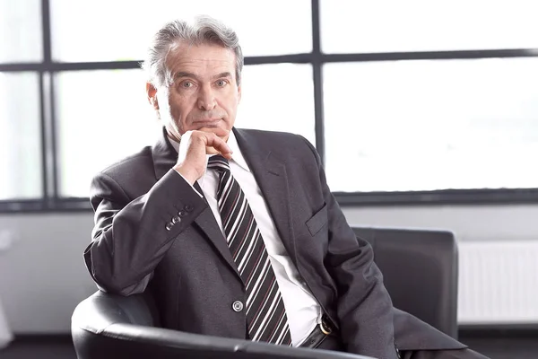 Executive businessman sitting in an office chair — Stock Photo, Image