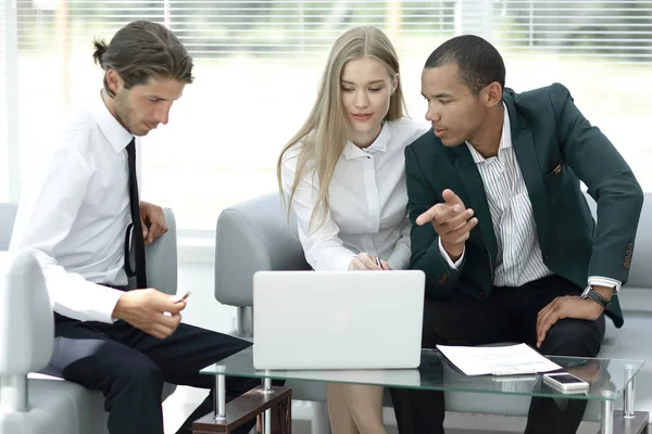 Equipo de negocios discutiendo información con un ordenador portátil — Foto de Stock