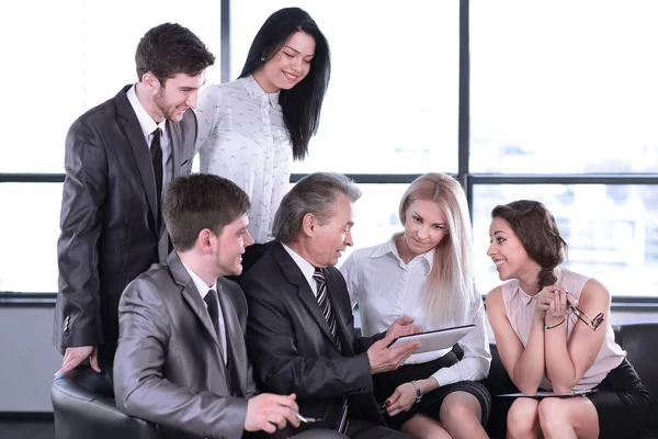 Businessman uses a digital tablet at a working meeting with employees — Stock Photo, Image