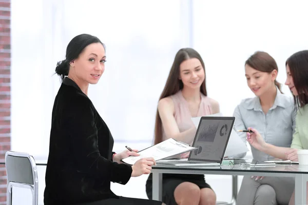 Donna d'affari adulta e gruppo di giovani dipendenti al lavoro Scrivania — Foto Stock