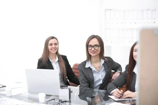 Три ділові жінки сидять на робочому столі в офісі.фотографія з копіювальним простором — стокове фото