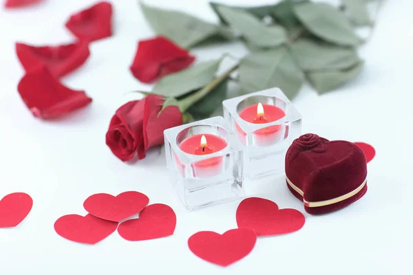 Romantiska koncept. Ring, ljus och ros på vit bakgrund — Stockfoto