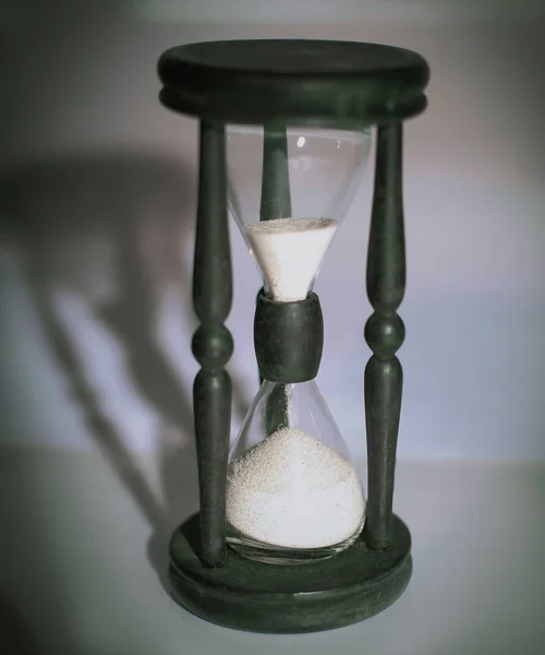Reloj de arena sobre fondo oscuro.el concepto de tiempo — Foto de Stock