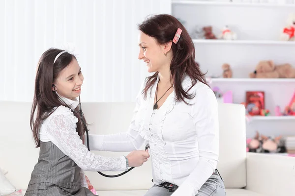 Menina brinca com sua mãe no médico — Fotografia de Stock