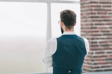 arka görüş. işadamı ofis pencereden bakıyor. kopya alanı ile fotoğraf