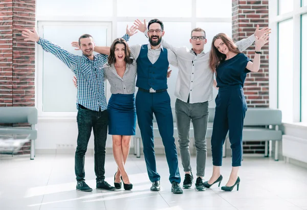Ευτυχισμένος επιχειρηματική ομάδα στέκεται σε ένα φωτεινό γραφείο — Φωτογραφία Αρχείου