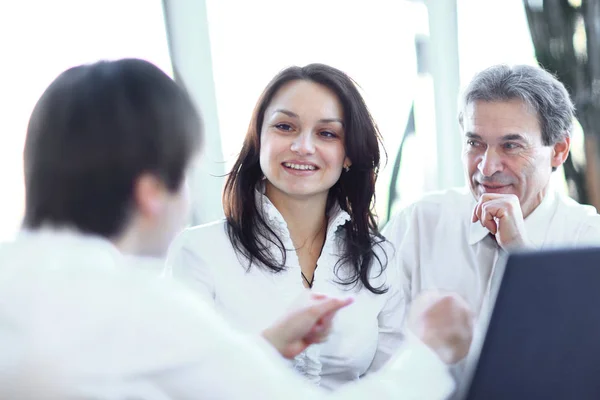 Primer plano. equipo de negocios hablando mientras está sentado en su escritorio — Foto de Stock